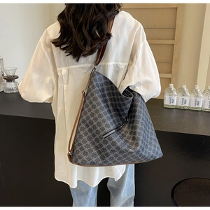 Detail of grey geometric tote bag with brown leather strap and front zipper pocket