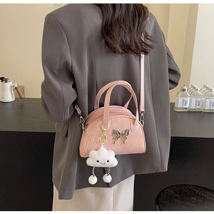 Sac carré rose avec papillon argenté et breloque nuage en peluche sur un modèle chic