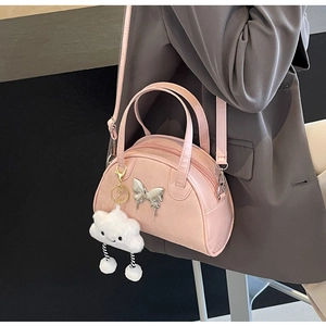 Vue détaillée du sac à main rose semi-circulaire avec papillon argenté et charm nuage
