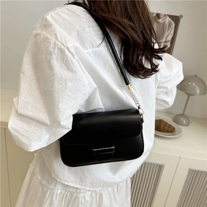 Sac bandoulière minimaliste en similicuir noir avec chaîne dorée et boucle métal