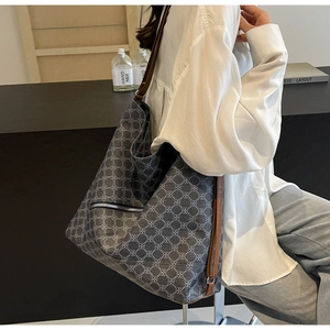 Detail of large tote bag with side zipper pocket and brown leather shoulder strap