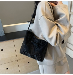 Gros plan du sac cabas plissé noir avec un nœud décoratif sur la surface texturée