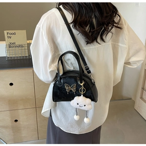 Détail du petit sac carré noir avec boucle papillon et pendentif nuage en peluche