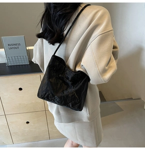 Détail d'un sac cabas plissé noir avec texture fine et fines bandoulières chics
