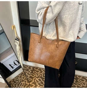 Brown vintage faux leather tote bag worn by a model in a minimal daily outfit style
