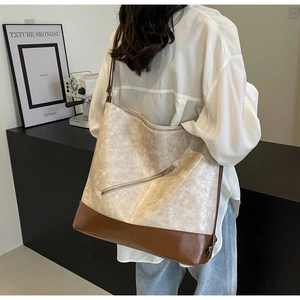 Detail view of large tote bag with dual-tone faux leather and diagonal silver zipper