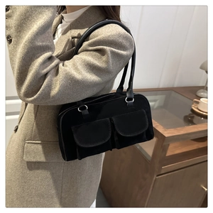 Detail of vintage black velvet underarm bag with double pockets on khaki blazer