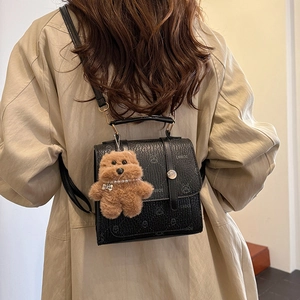Minimalist black faux leather backpack with retro texture and cute bear pendant charm