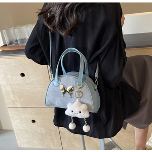 Sac Boston bleu avec détail papillon argenté et breloque en peluche nuage blanc