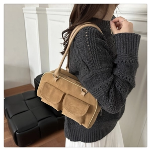 Detail of a brown suede Boston bag with double front pockets and long shoulder straps