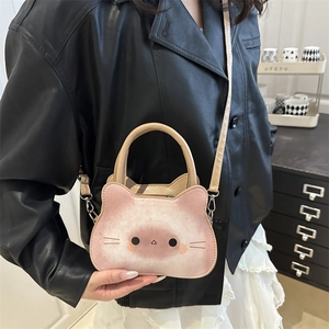 Sac à bandoulière en cuir chat rose et beige avec poignées porté par mannequin