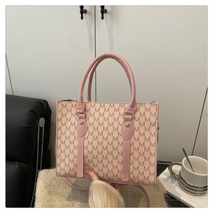 Chic pink handbag with M-pattern texture and gold stud details in a lifestyle setting