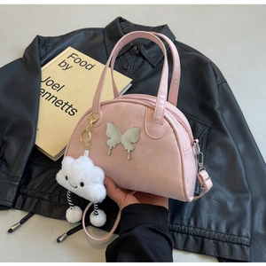 Vue détaillée du sac rose demi-lune avec papillon argenté et charm nuage en peluche