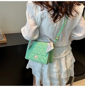 Détail du sac matelassé vert menthe avec poignée foulard et fermoir bouclier argent