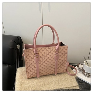 Detail of pink monogram pattern tote bag with leather handles and metallic hardware