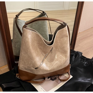 Detail showing vintage textured PU leather tote with diagonal zipper and dual-tone design