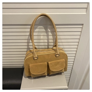 Detail of ginger yellow matte handbag showing front double pockets and top zipper