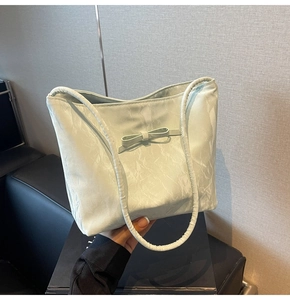 Détail d'un sac cabas vert menthe avec texture plissée et décoration de nœud