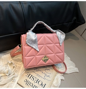 Détail du sac à main matelassé rose avec poignée en soie et fermoir doré géométrique