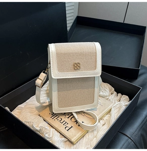 Detail view of woven beige texture and white leather flap with clover metal lock