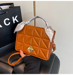 Détail du sac carré matelassé caramel avec fermoir doré et poignée en foulard de soie