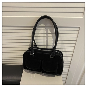 Detail of black suede shoulder bag featuring double front flap pockets and silver zipper