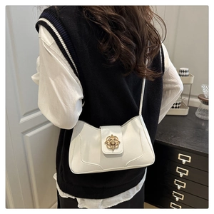 Close-up of white leather crossbody bag featuring a golden floral metal buckle