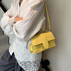 Chic bright yellow crossbody square bag with pearl tassel shown on model with lace top