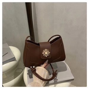Vue détaillée du sac en cuir marron avec un fermoir métallique fleuri doré élégant