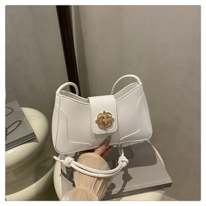 Détail du sac bandoulière en similicuir blanc avec une boucle dorée en forme d'étoile