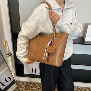 Minimalist brown faux leather tote bag with cute bear charm and woven rope decoration