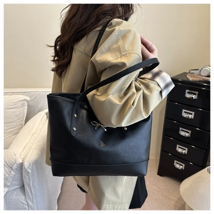 Damen-Shopper aus schwarzem Leder mit goldener Schleife in stilvoller Inneneinrichtung