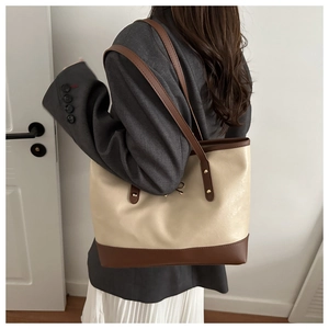 Detail einer großen zweifarbigen Tragetasche aus PU-Leder in Creme und Braun