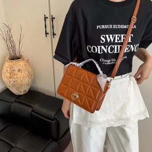 Sac bandoulière marron matelassé avec fermoir doré et foulard en soie sur modèle