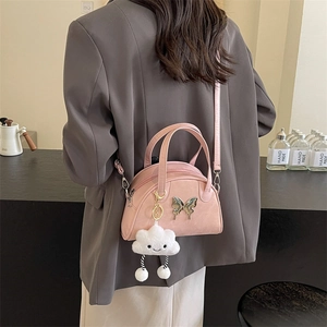 Sac bandoulière rose minimaliste avec boucle papillon et breloque nuage sur blazer gris