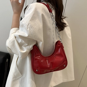 Red patent leather crescent moon shoulder bag with silver chain strap and metal rivets