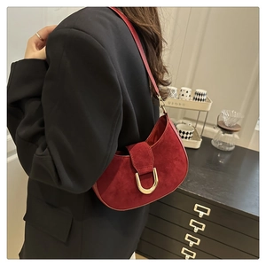 Dettaglio borsa hobo in camoscio bordeaux con fibbia a D dorata sulla spalla