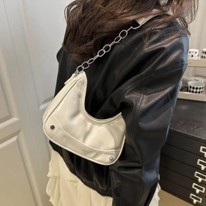White crescent moon shoulder bag with silver studs and chain strap on a model