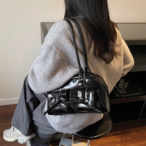 Sac à épaule minimaliste en cuir noir brillant avec nœuds et deux poches frontales