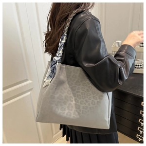 Detail of grey leopard print tote bag with stylish blue and white silk scarf handle decoration