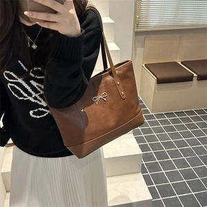 Braune Leder-Einkaufstasche mit goldener Schleife im eleganten City-Lifestyle-Ambiente