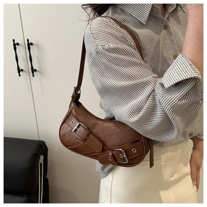 Detail of vintage brown crescent bag showing silver buckle and premium leather texture