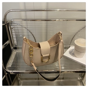 Dettaglio della borsa beige a mezzaluna con fibbia a ferro di cavallo dorata e catenella