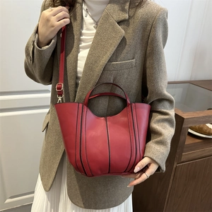 Deep red trapezoid handbag with black stitching and adjustable strap for women