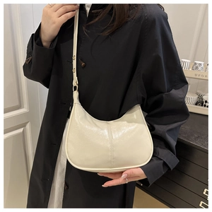 Detail of the cream hobo bag shown in a lifestyle setting with an adjustable strap