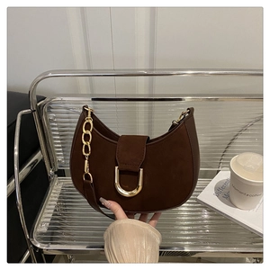 Dettaglio borsa hobo in pelle scamosciata marrone con fibbia a U e tracolla a catena