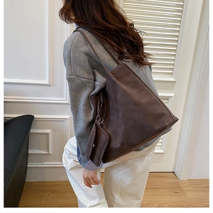 Brown faux suede oversized tote bag with matching coin purse shown on a model shoulder