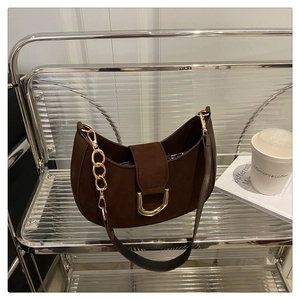 Dettaglio della borsa hobo in pelle scamosciata marrone con catena e fibbia oro