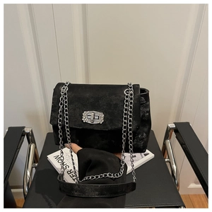 Detail of black textured crossbody bag featuring a sparkling diamond metal buckle