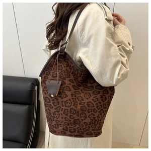 Dettaglio della borsa tote leopardata con cinturini in pelle marrone e trench beige